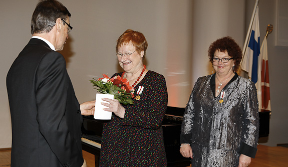 STKL:n puheenjohtaja Raimo Lindberg ja toiminnanjohtaja Riitta Särkelä luovuttivat presidentti Haloselle mitalin.